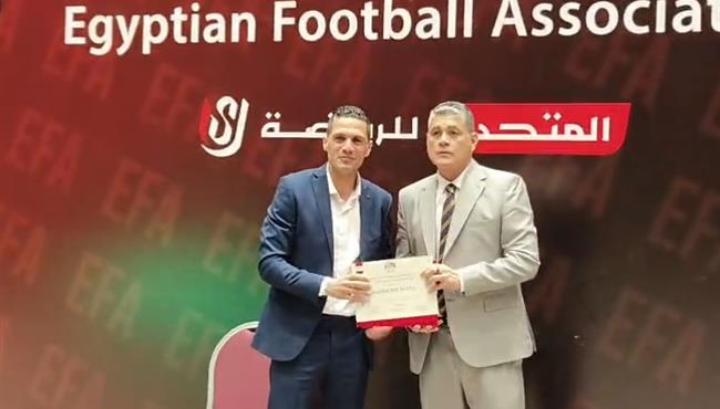 أوسكار رويز يلتقط صورة تذكارية مع محمود وفا بعد استلامه للشارة الدولية