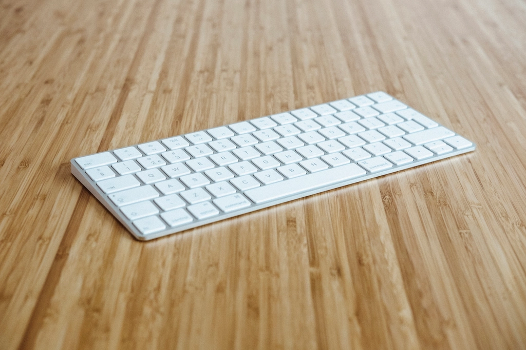 White wireless earbuds and charging case on a light surface