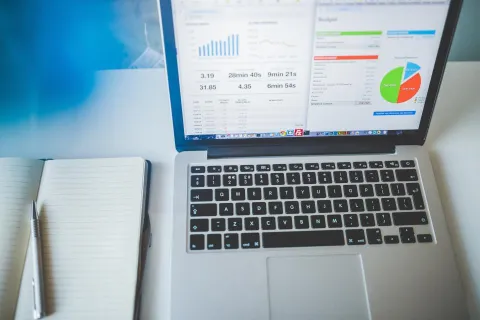 مكتب عمل حديث يحتوي على حاسوب محمول وأدوات مكتبية لمقارنة برامج الإنتاجية