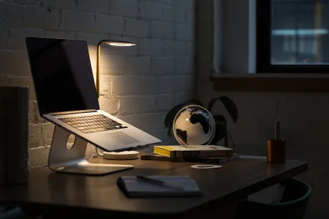 كمبيوتر محمول حديث مفتوح على مكتب عمل خشبي أنيق