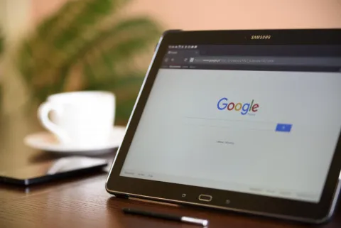 شاشة هاتف ذكي تعرض واجهة تطبيق مساعد الذكاء الاصطناعي على مكتب عمل