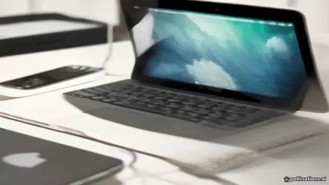 An iPhone and a Mac syncing data via iCloud on a desk.