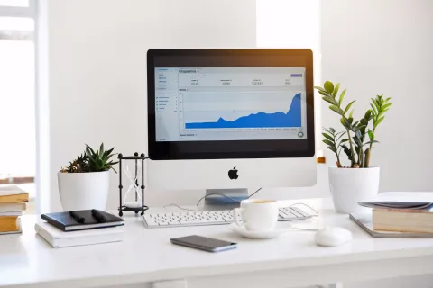Computer monitor displaying email client interface on a clean desk