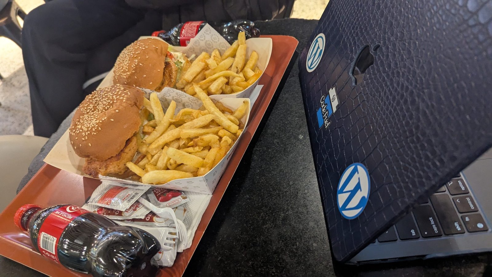 Two modern laptops displaying AI interfaces side by side on a clean desk.