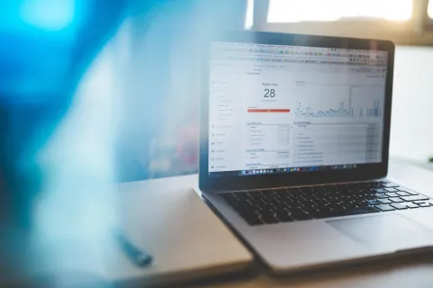 كمبيوتر محمول يعرض نافذة متصفح إنترنت على مكتب خشبي أنيق