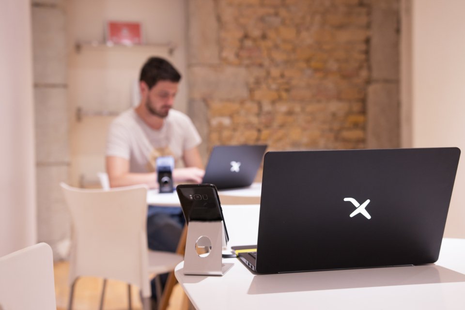 A laptop sitting on a wooden desk next to a modern wireless router