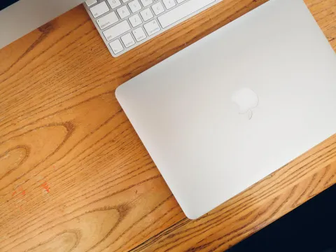 Laptop and desktop computer setup on a clean wooden desk
