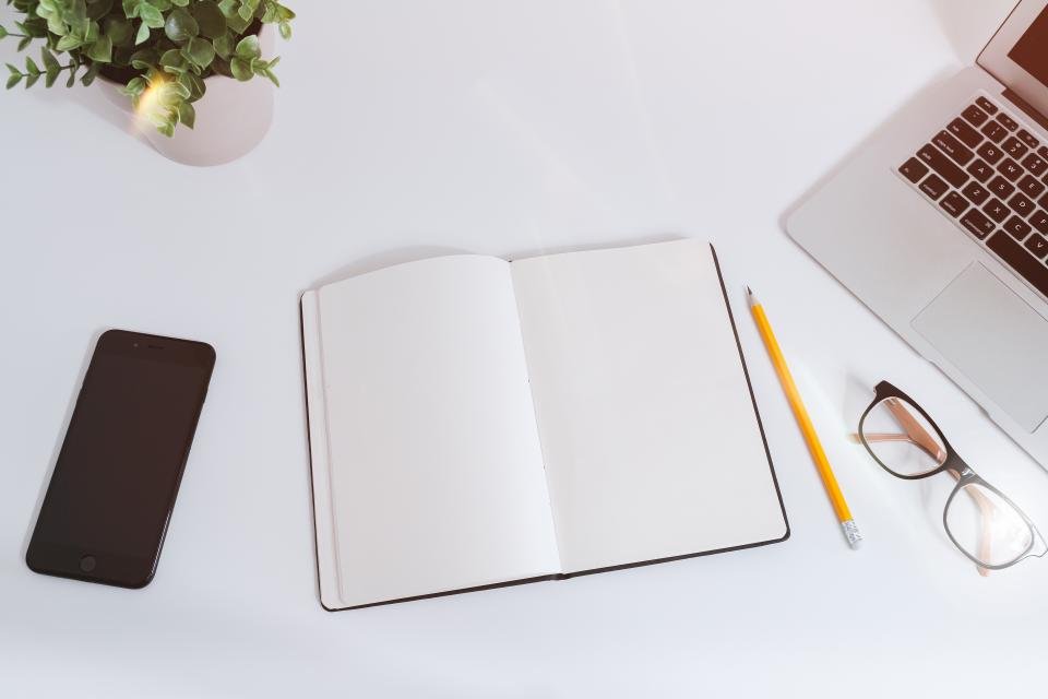 باحث يقرأ ويلخص أوراقاً علمية باستخدام لابتوب على مكتب دراسي منظم