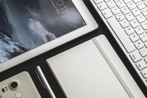جهاز آيباد بشاشة سوداء على مكتب خشبي أثناء محاولة الشحن والصيانة