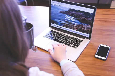 A laptop and smartphone on a desk showing an AI application.