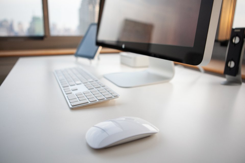 A laptop displaying a document editor on a clean wooden desk.