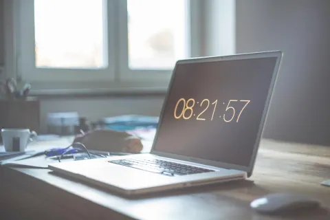 حاسوب محمول يعرض إعدادات النظام في مكتب عمل حديث